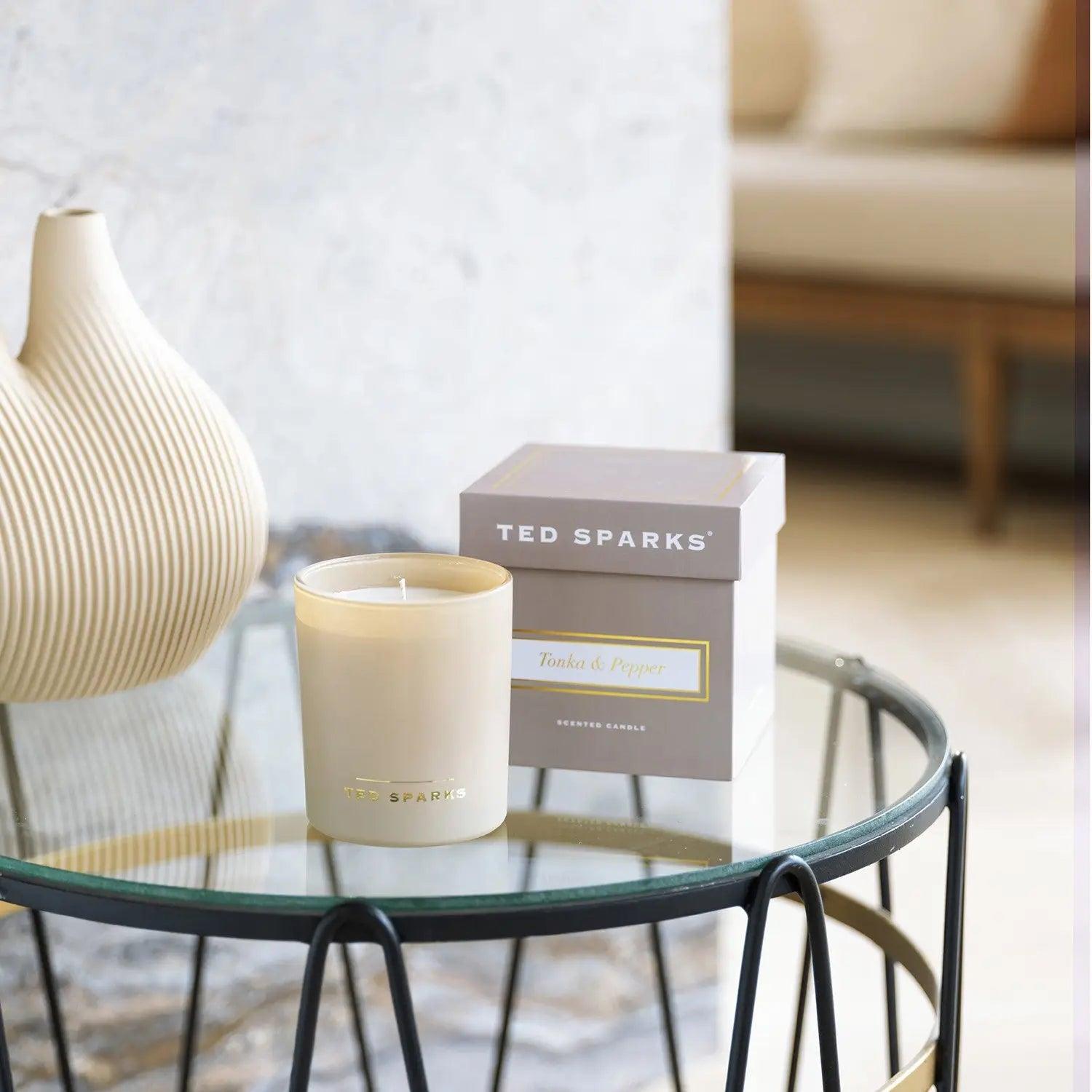 Ted Sparks candle and packaging on a stylish table, showcasing luxury home fragrance in elegant design.